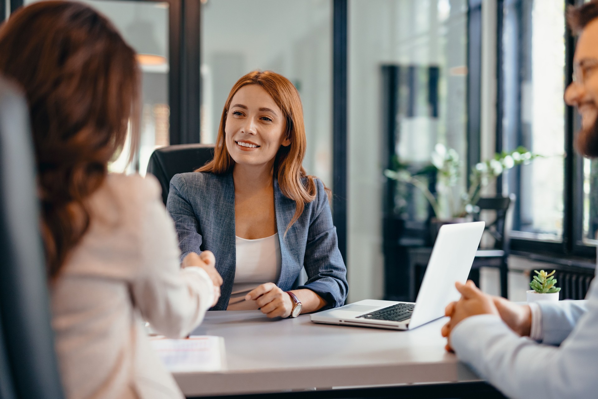 Three professionals in a discussion at an office meeting setting.